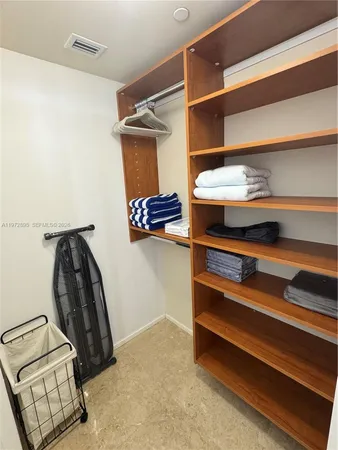 a view of walk in closet with clothes