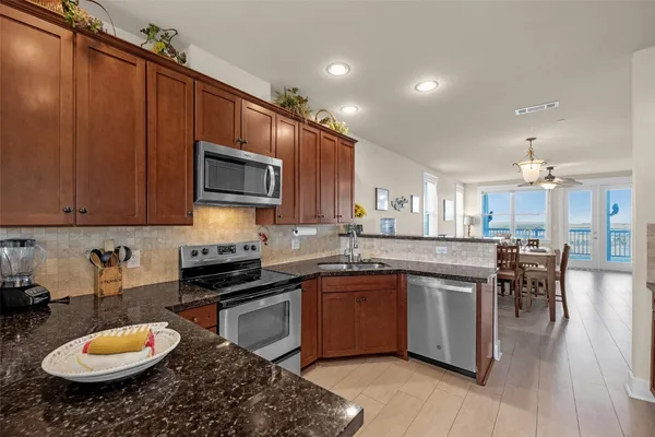 a kitchen with stainless steel appliances granite countertop a stove sink and cabinets