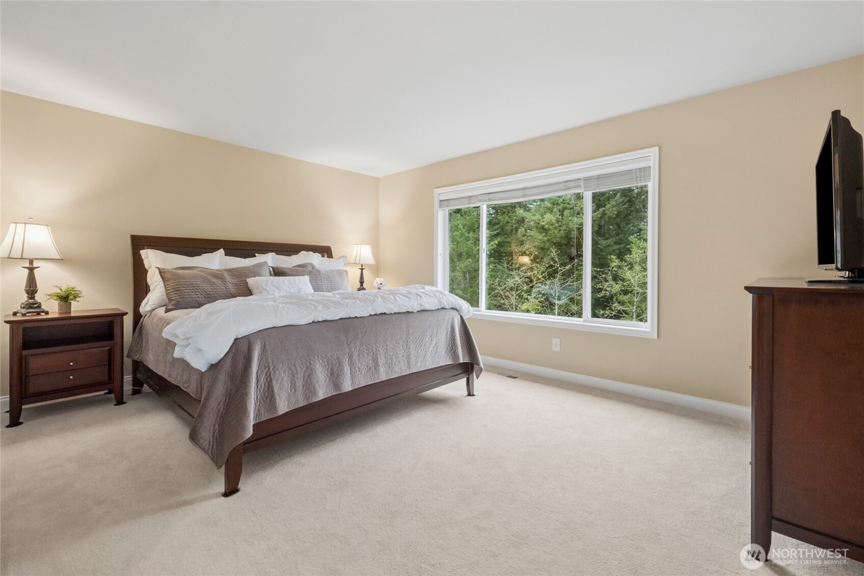 6701 West Crestview Loop Southeast Snoqualmie, WA 98065 - Photo 19 of 40 a bedroom with a bed flat screen tv and a large window