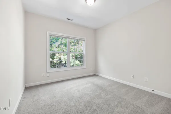 an empty room with windows and ceiling fan