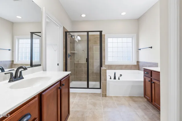 a bathroom with a tub sink and mirror