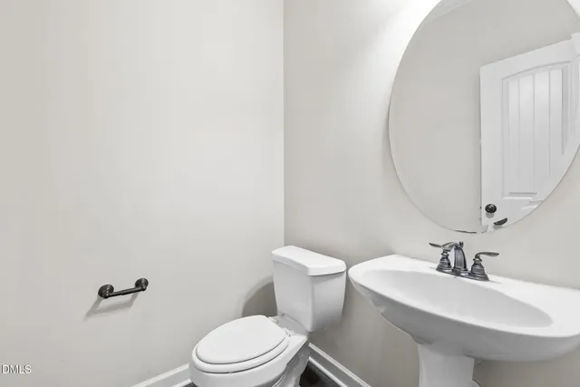 a white toilet sitting next to a bathroom sink