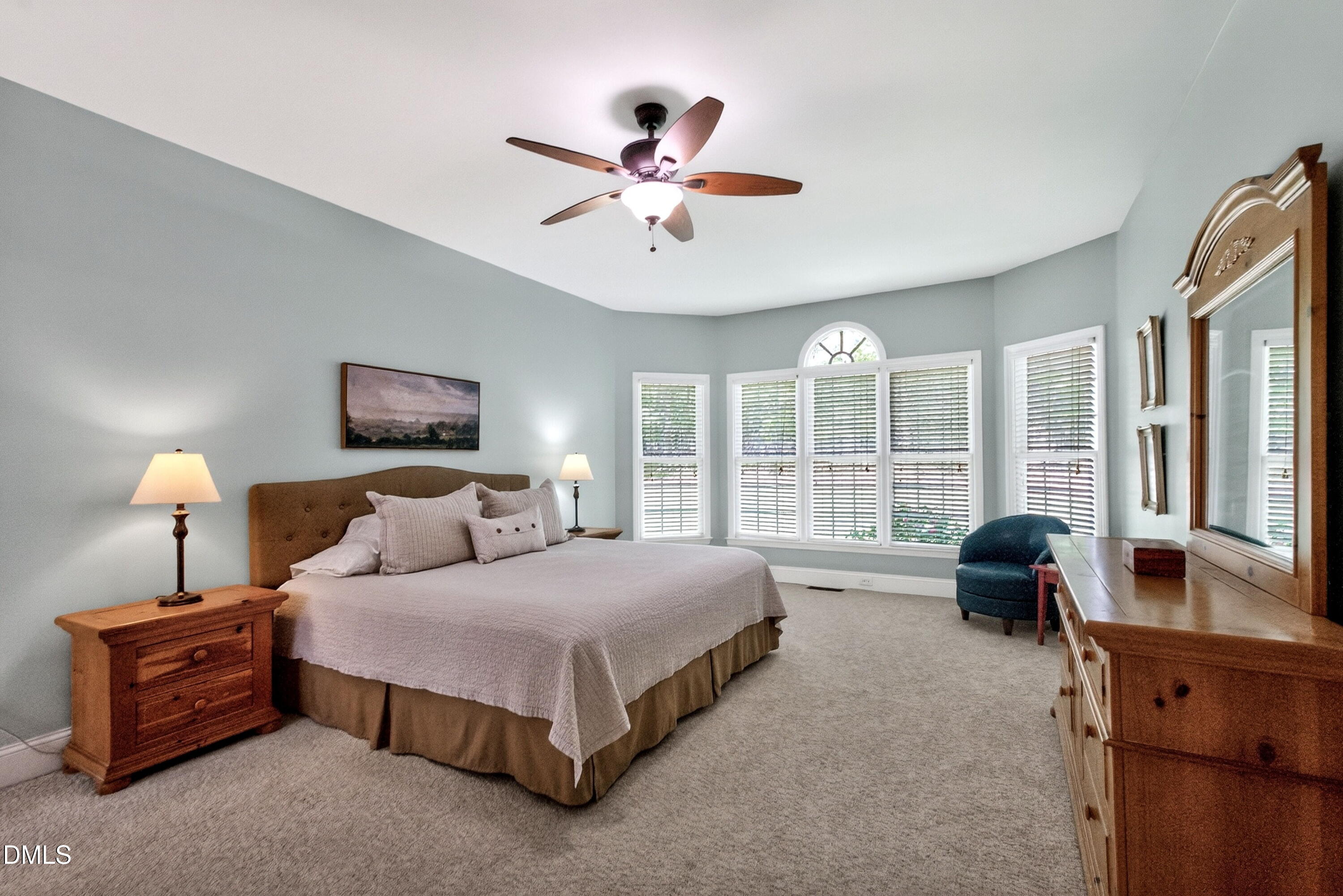 6329 Battleview Drive Raleigh, NC 27613 - Photo 18 of 36 a spacious bedroom with a bed and a chandelier