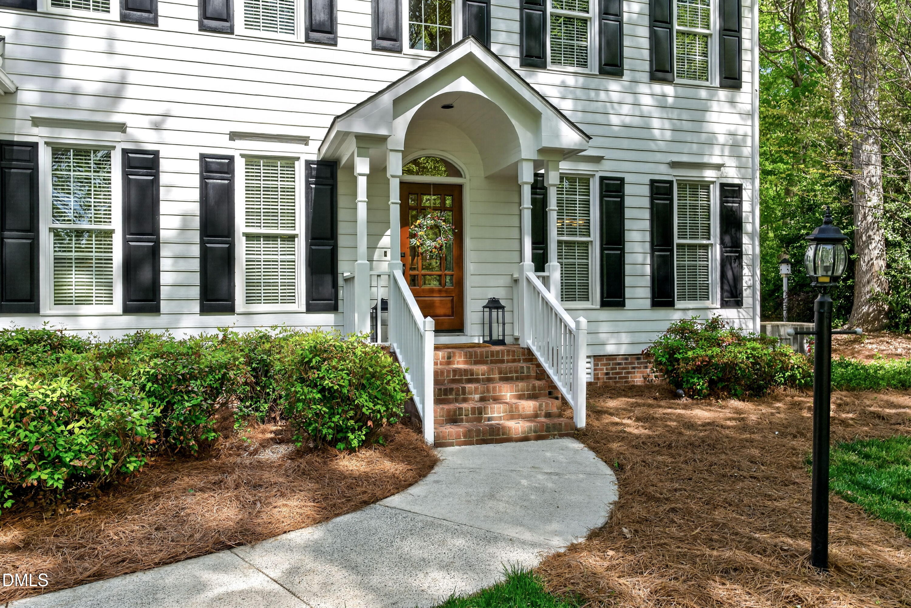 6329 Battleview Drive Raleigh, NC 27613 - Photo 3 of 36 a view of a white house with large windows and a small yard plants and large tree