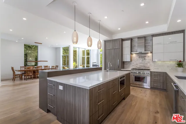 a kitchen with stainless steel appliances granite countertop a stove a sink a oven and a refrigerator