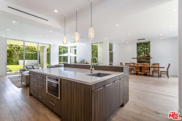 a kitchen with stainless steel appliances granite countertop sink wooden cabinets and wooden floor