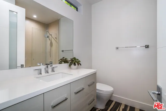 a bathroom with a sink a toilet and mirror