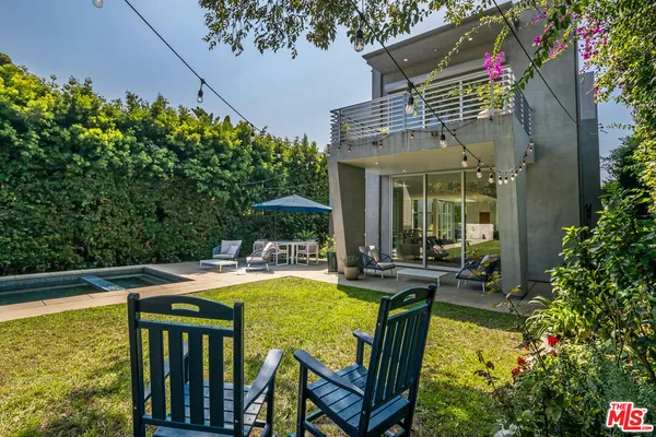 a view of a house with pool and a yard