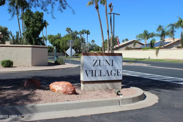 a view of a house with table and chairs under an umbrella