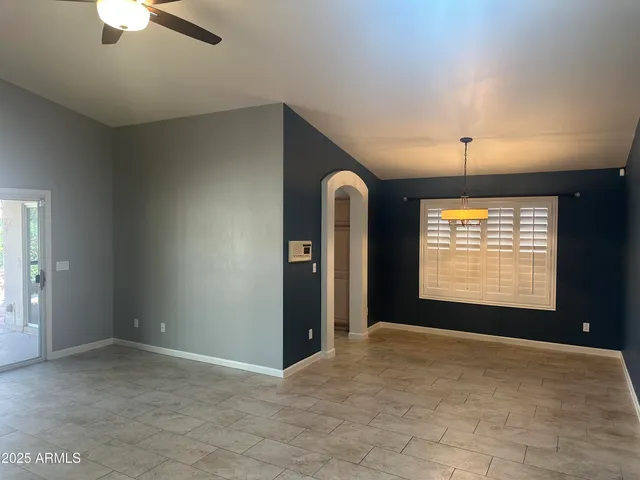 en empty room with windows and fan