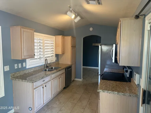 a kitchen with granite countertop a sink and a stove top oven