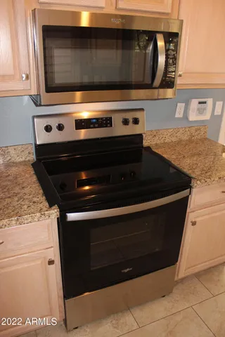 a bathroom with a granite countertop sink and a window