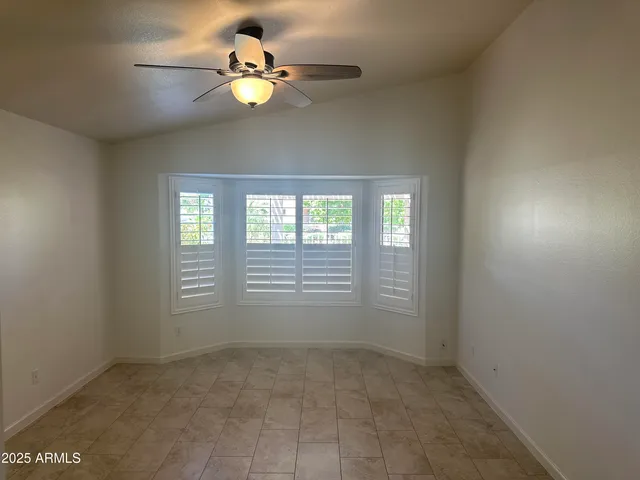 an empty room with a ceiling fan and a fan