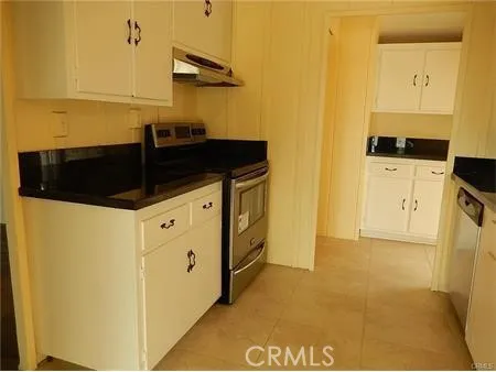 a kitchen with granite countertop cabinets stove and microwave