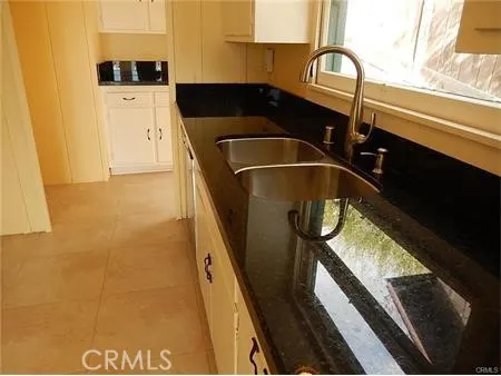 a kitchen with white cabinets and black appliances