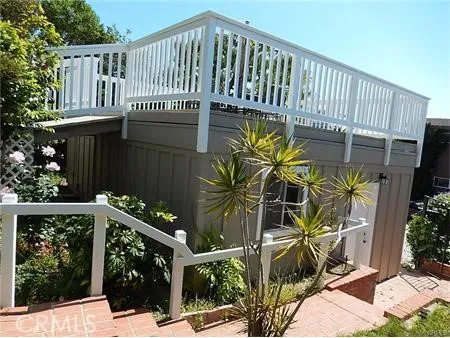 a view of a house with a small yard and wooden fence