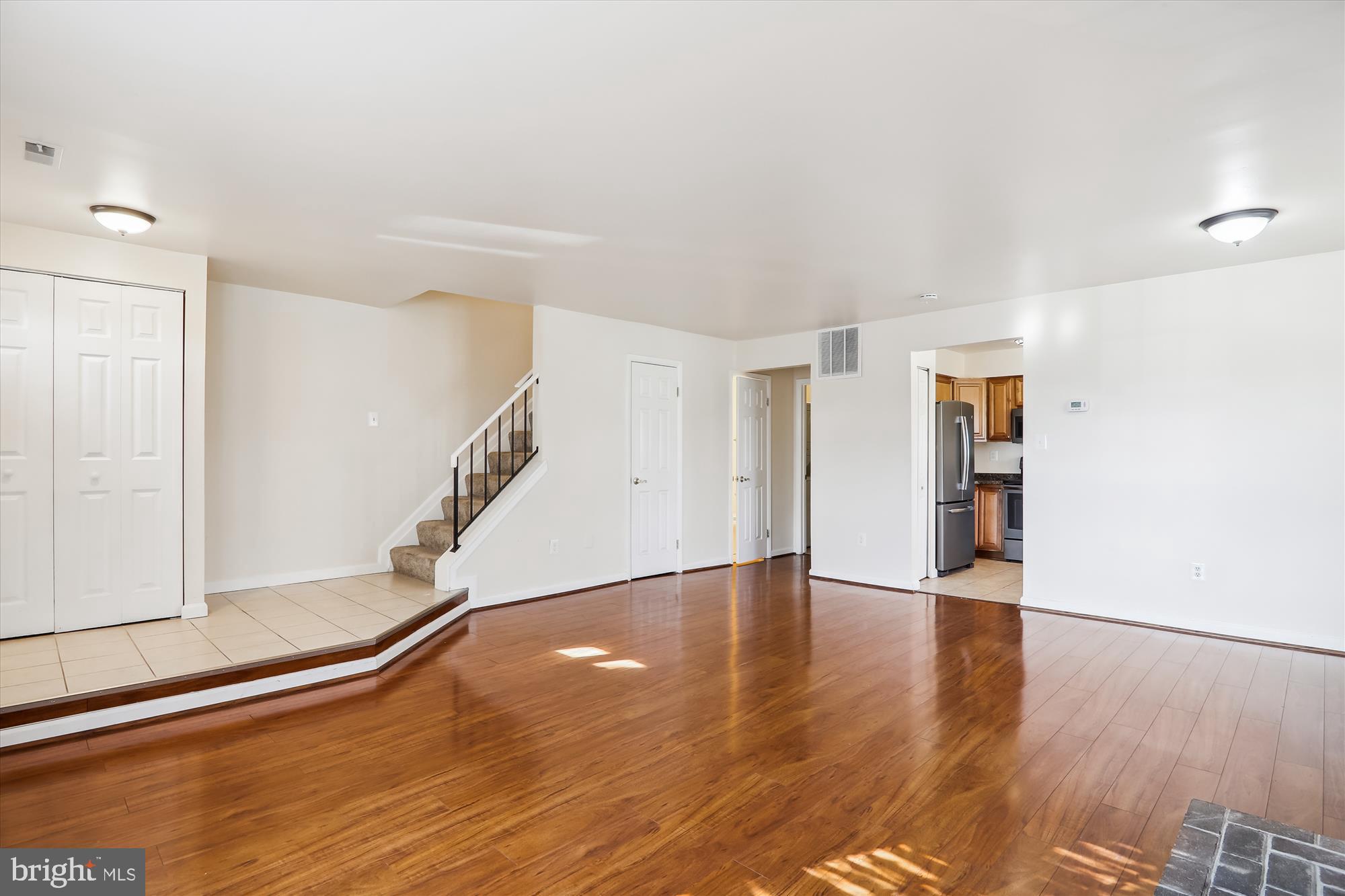 13164 Musicmaster Drive, Unit 144 Silver Spring, MD 20904 - Photo 4 of 31 a view of an empty room with wooden floor and stairs