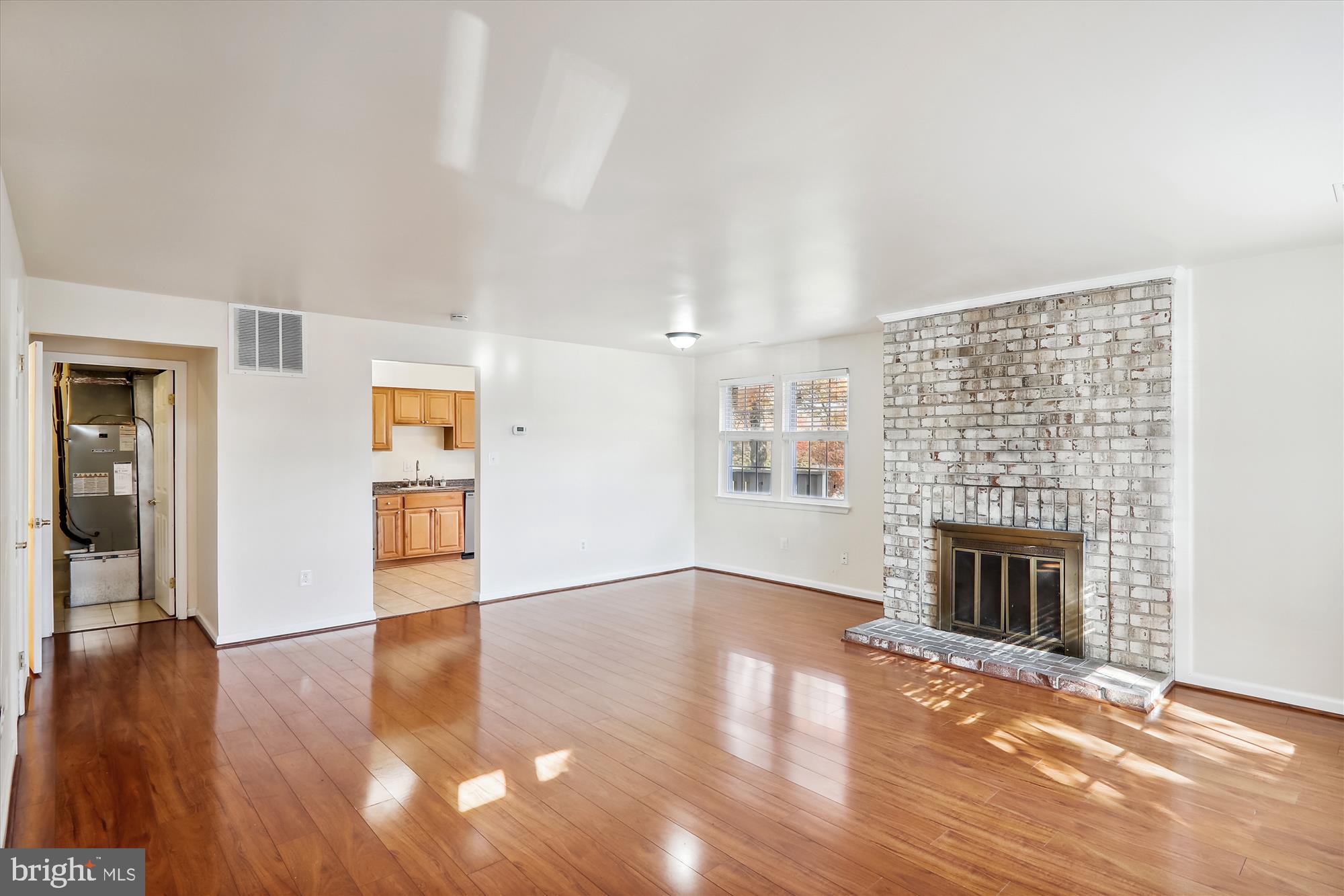 13164 Musicmaster Drive, Unit 144 Silver Spring, MD 20904 - Photo 5 of 31 an empty room with wooden floor fireplace and windows