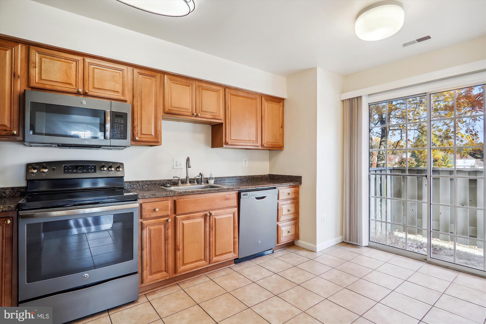 13164 Musicmaster Drive, Unit 144 Silver Spring, MD 20904 - Photo 6 of 31 a kitchen with granite countertop cabinets stainless steel appliances and a window