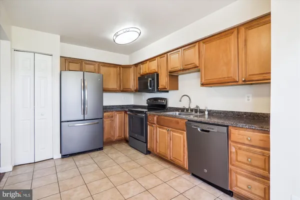 a kitchen with stainless steel appliances granite countertop a refrigerator sink and stove