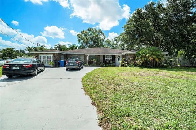 a view of a white house with a large tree