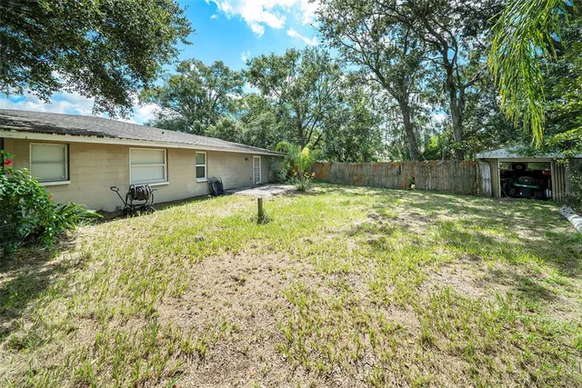 a backyard of a house with yard and trampoline