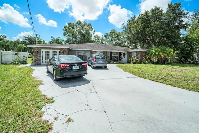 a car parked in front of a house next to a yard