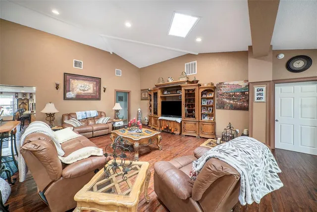 a living room with furniture a flat screen tv and a large window