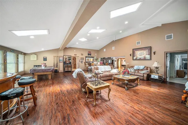 a living room with lots of furniture wooden floor and a table