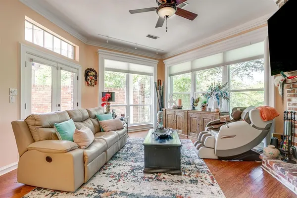 a living room with furniture a flat screen tv and a large window