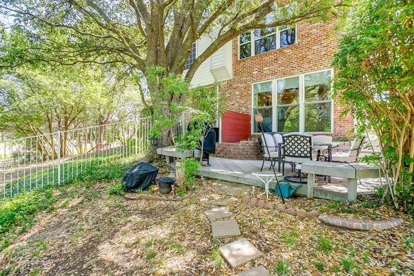 a view of a patio with table and chairs near a garden