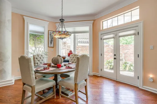 a dining room with furniture a chandelier and wooden floor
