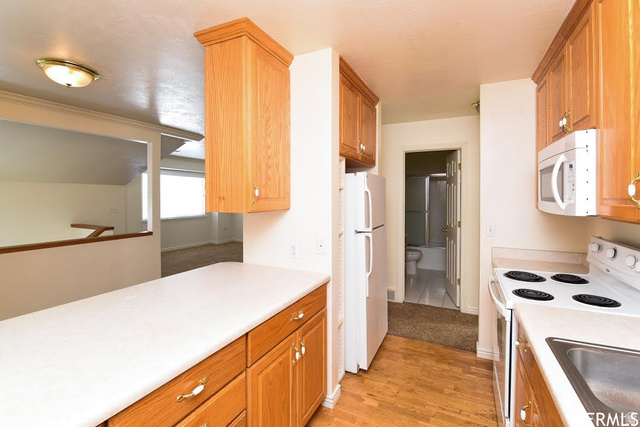 1130 North 200 West Bountiful, UT 84010 - Photo 6 of 11 Kitchen with white appliances, light wood-type flooring, light countertops, and wood finish cabinets