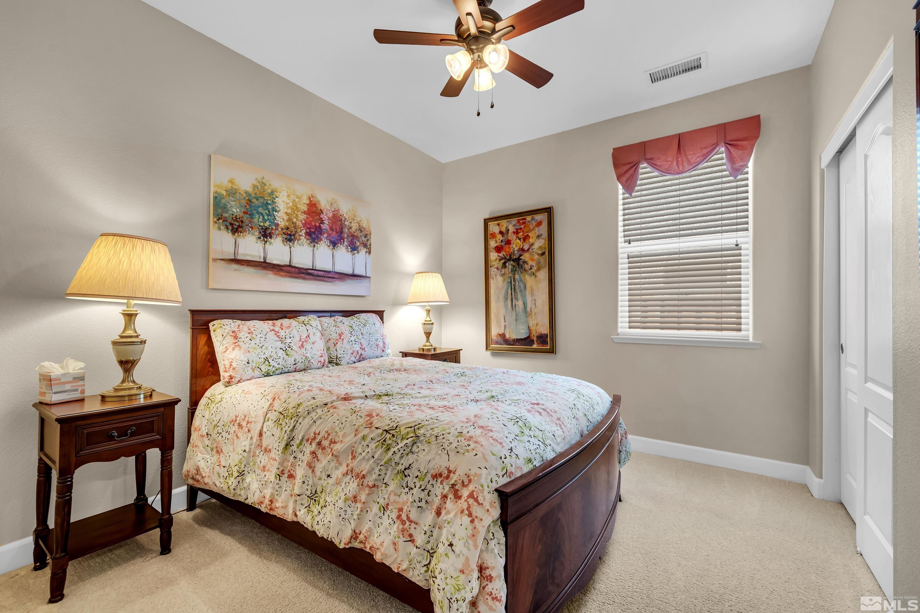 420 Manciano Way Reno, NV 89521 - Photo 21 of 30 a bedroom with a bed and a chandelier