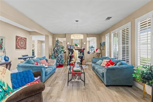 a kitchen with stainless steel appliances a stove top oven a sink dishwasher and white cabinets with wooden floor