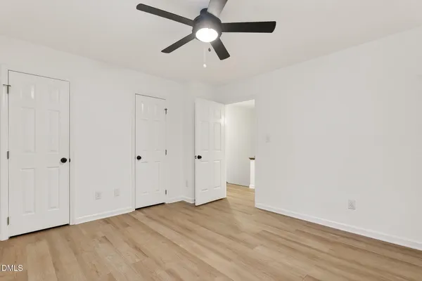 a view of empty room with wooden floor