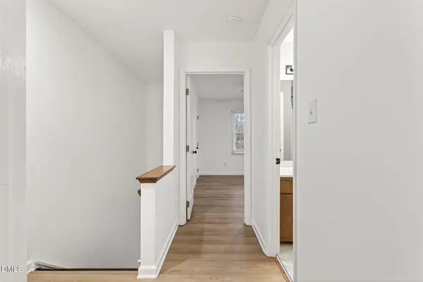 a view of a hallway with wooden floor and staircase