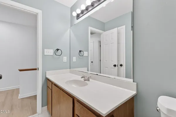 a bathroom with a sink a toilet and a mirror