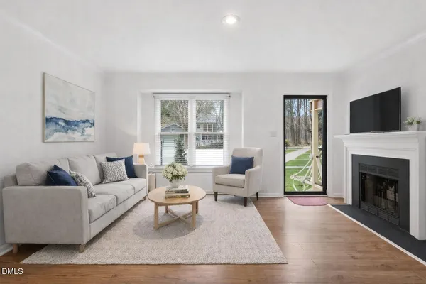 a living room with furniture a flat screen tv and a fireplace