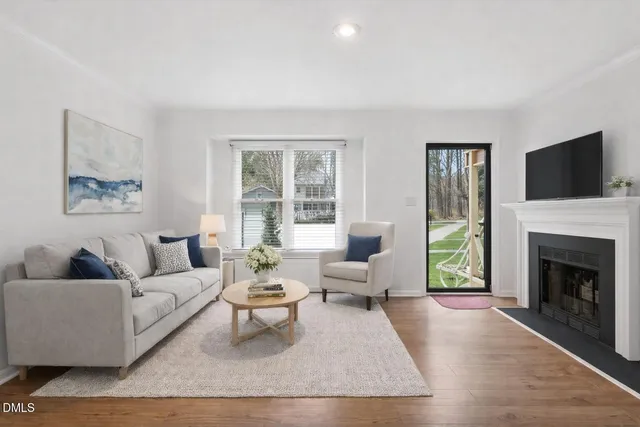 a living room with furniture a flat screen tv and a fireplace