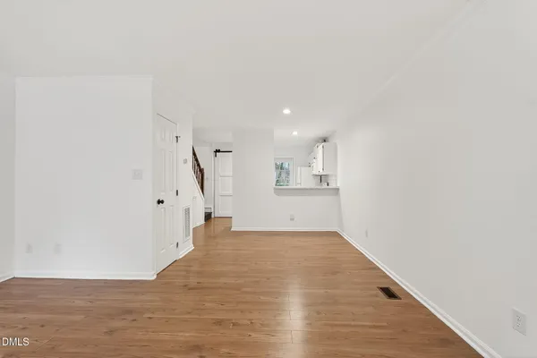 a view of empty room with wooden floor