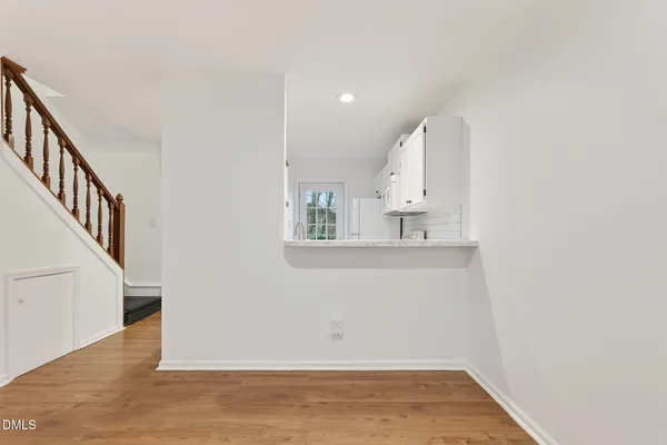 a view of a kitchen with wooden floor and staircase