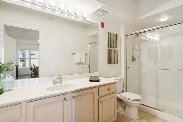 a bathroom with a sink a toilet and a large mirror