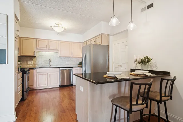 a kitchen with stainless steel appliances granite countertop a stove a sink and a refrigerator