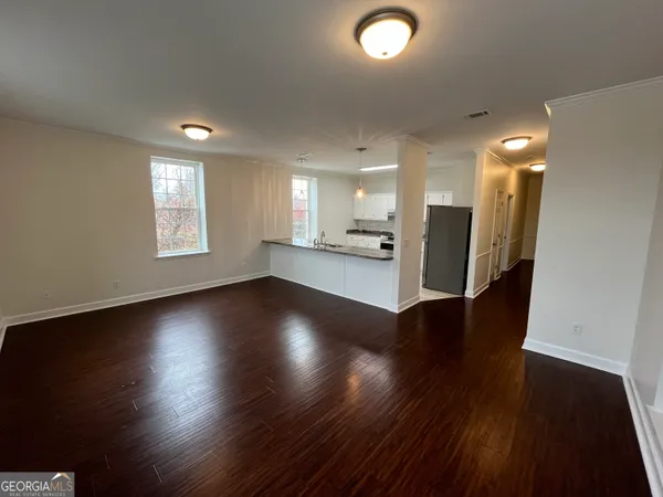 an empty room with wooden floor and windows