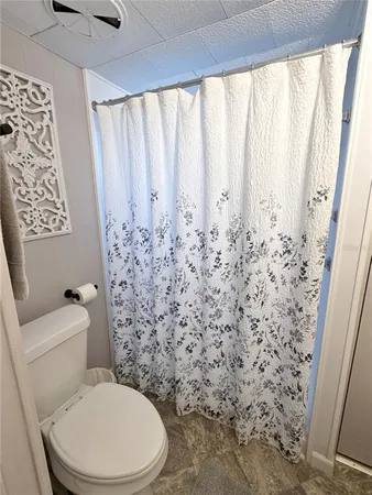 a white toilet sitting next to a shower curtain