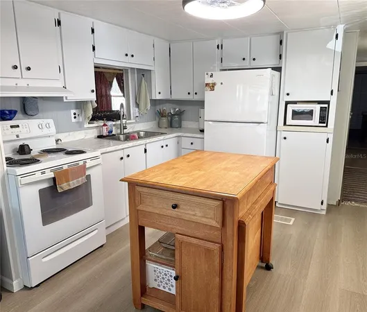 a kitchen with a stove a refrigerator and a sink