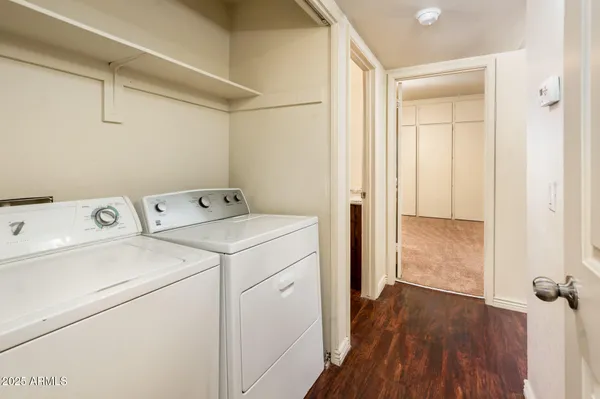 a view of washer and dryer with wooden cabinets