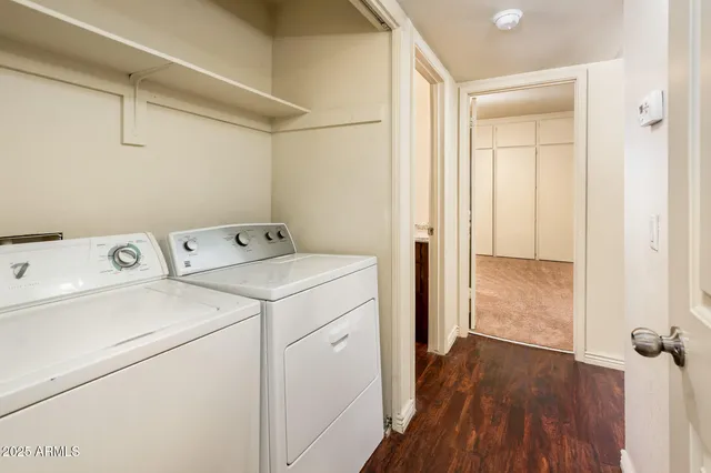 a view of washer and dryer with wooden cabinets