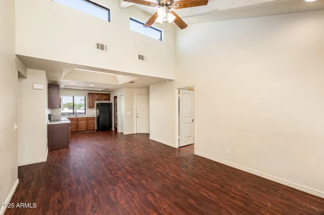 a living room with hard wood floors and a ceiling fan